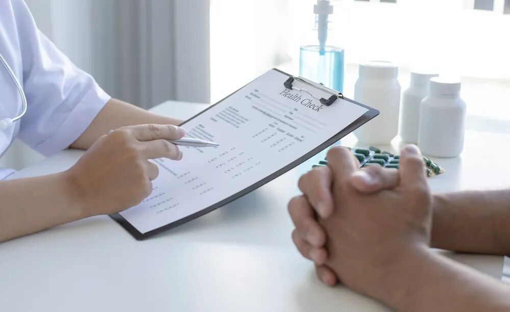 A clipboard and pen on a desk during a consultation discussion