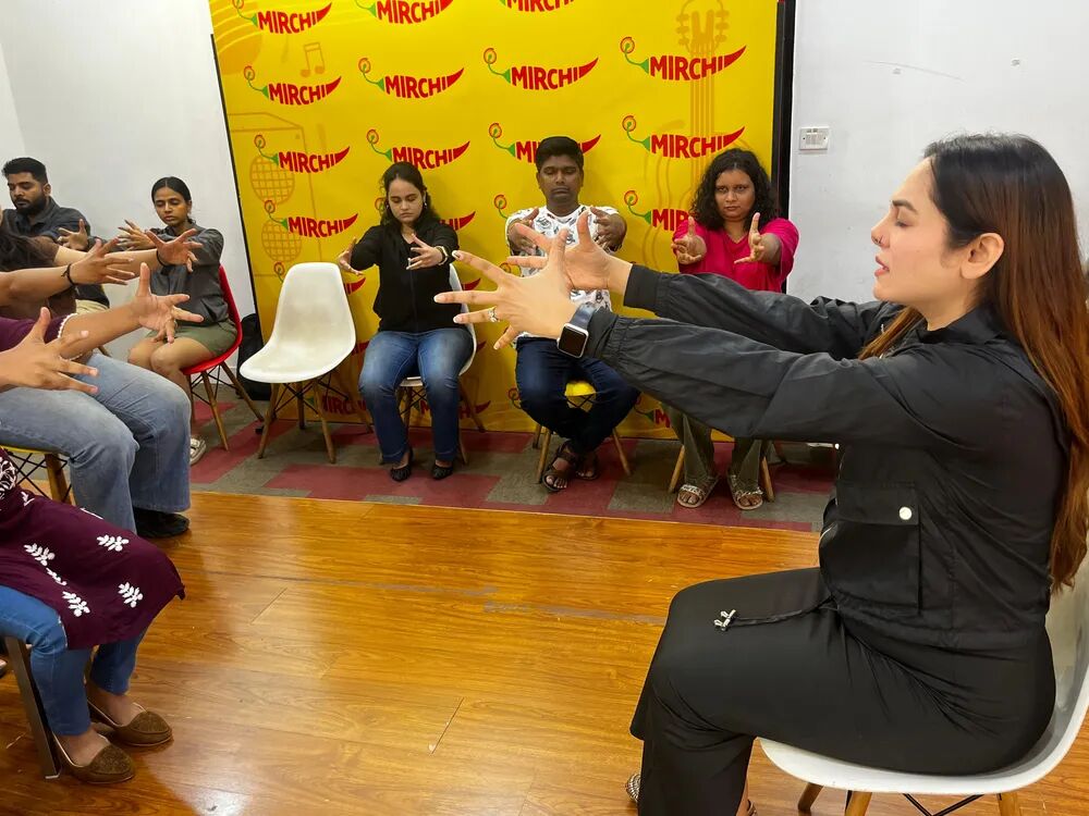 Vibha Jain guiding a group hypnotherapy demonstration session with participants seated in a circle